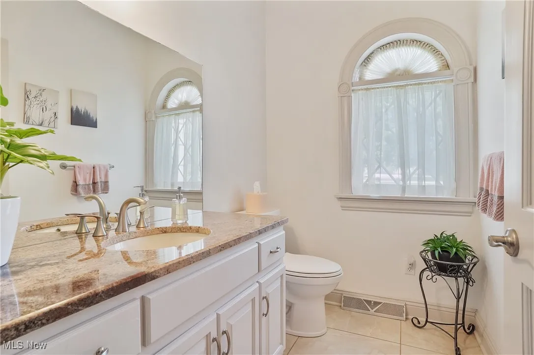 Bathroom with tile patterned floors, vanity, and healthy amount of natural light