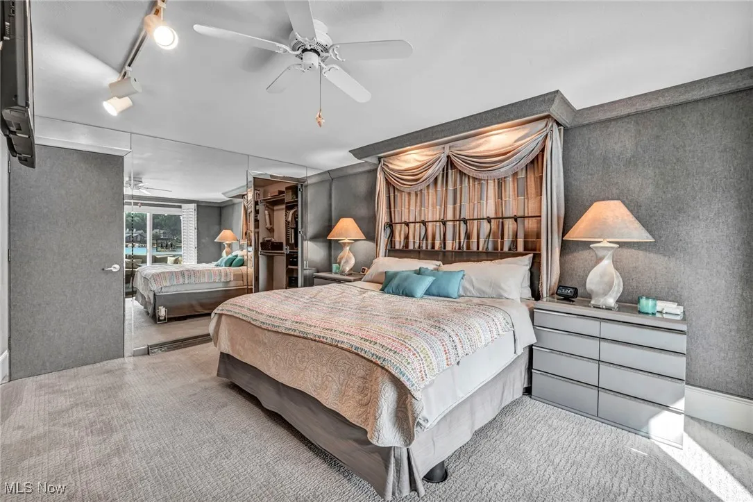 Bedroom featuring carpet floors, a ceiling fan, a walk in closet, and track lighting