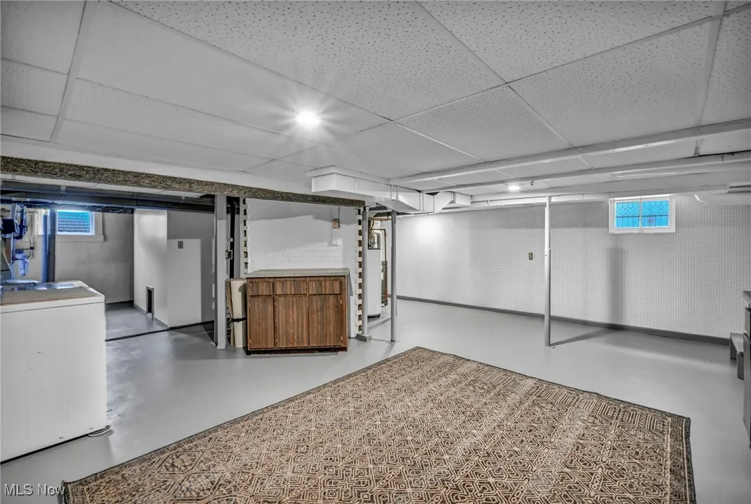 Below grade area with washer /  dryer, a paneled ceiling, and water heater