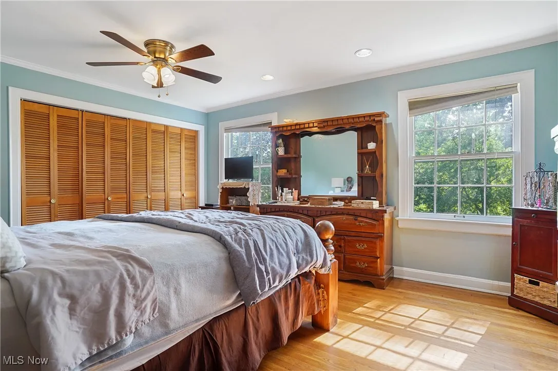 Bedroom featuring crown molding, light wood-style floors, a ceiling fan, recessed lighting, and a closet