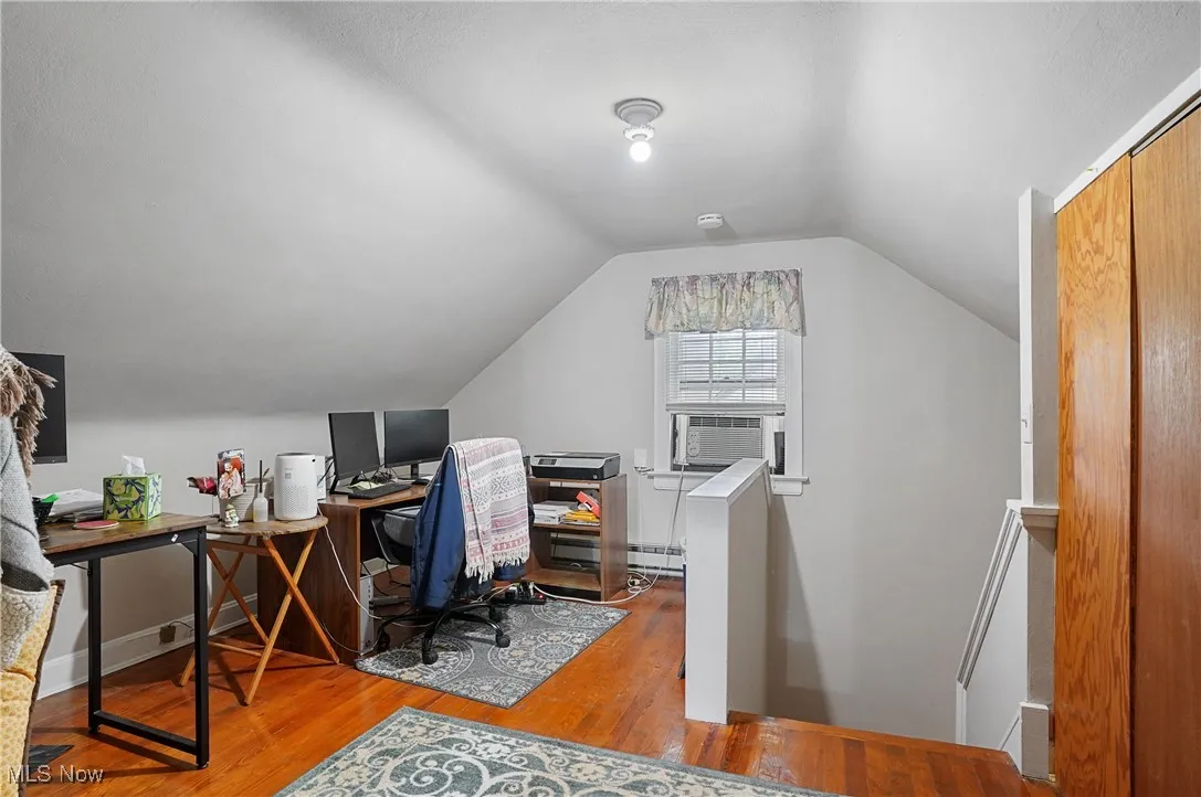 Home office featuring wood finished floors and lofted ceiling