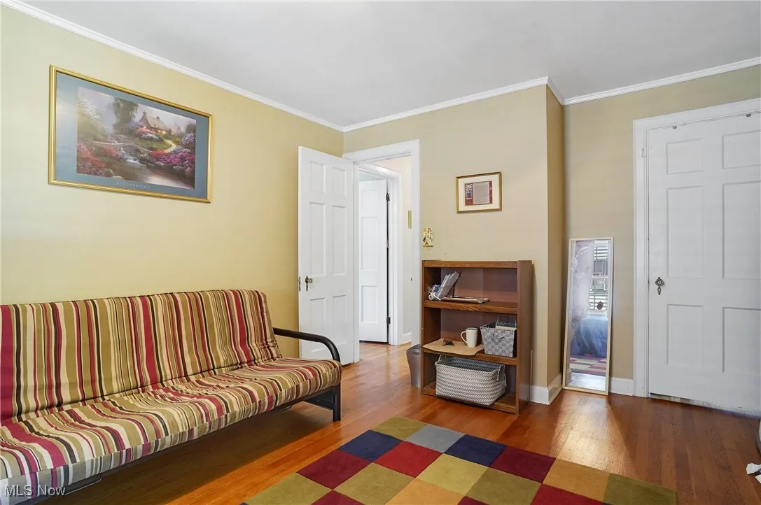 Living area featuring wood finished floors and crown molding