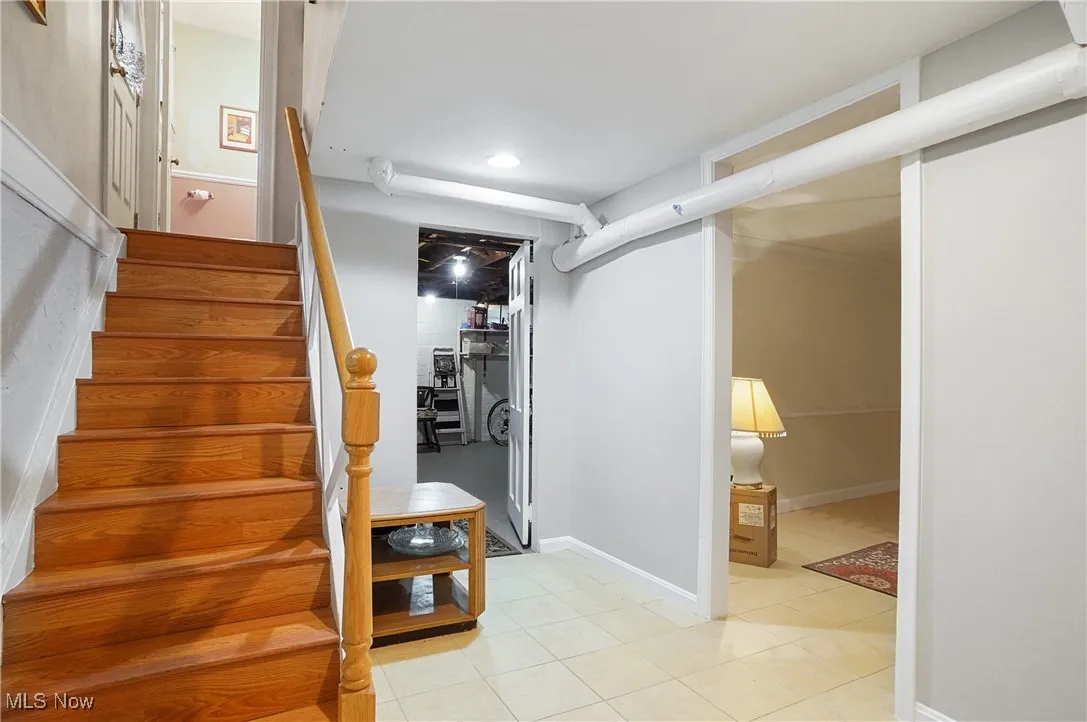 Staircase featuring tile patterned floors and recessed lighting