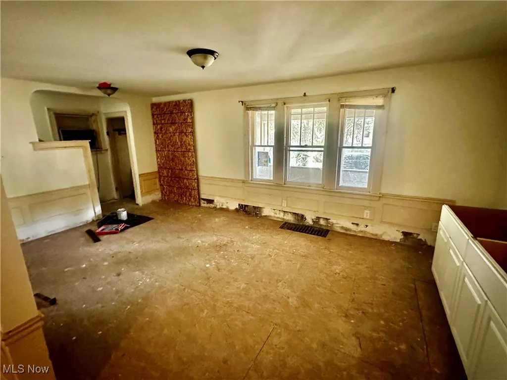 Empty room with a decorative wall and a wainscoted wall