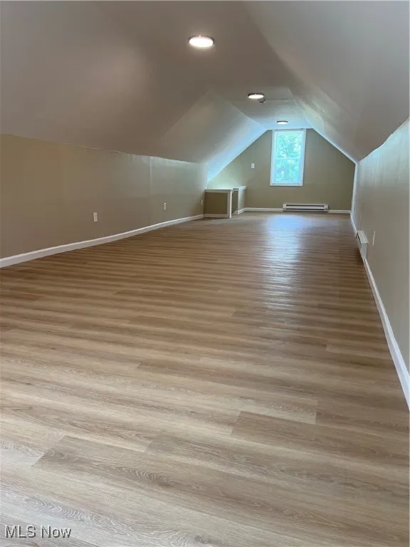 Bonus room featuring lofted ceiling, light wood-type flooring, and baseboard heating