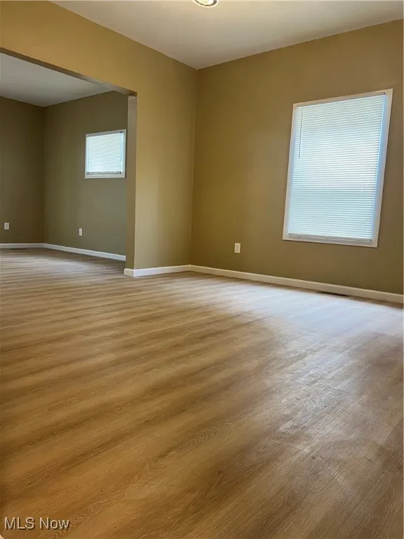 Spare room with baseboards and wood finished floors