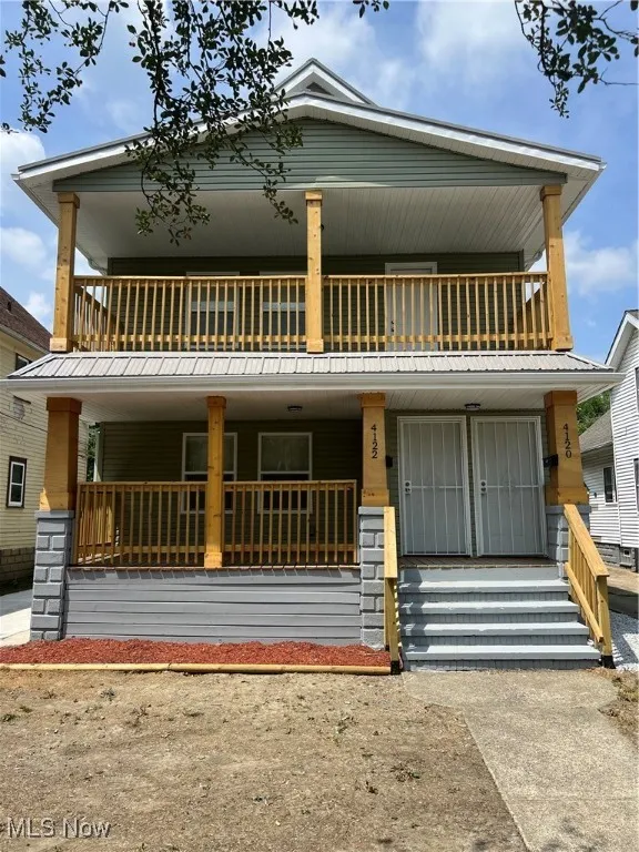 View of front of property with a balcony and a porch