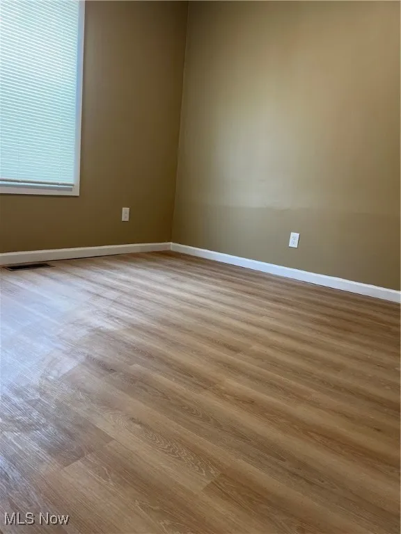Spare room featuring wood finished floors and baseboards