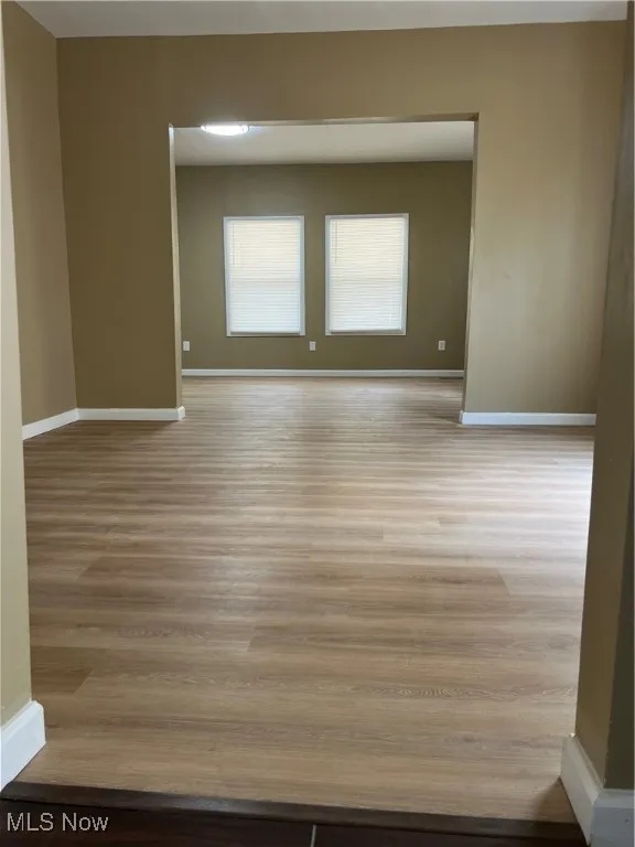 Unfurnished room with baseboards and wood finished floors