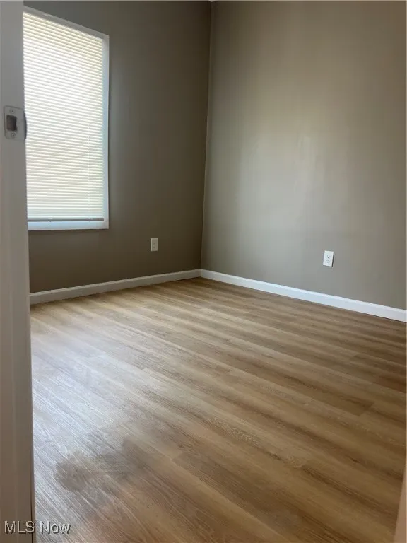 Empty room with baseboards and wood finished floors