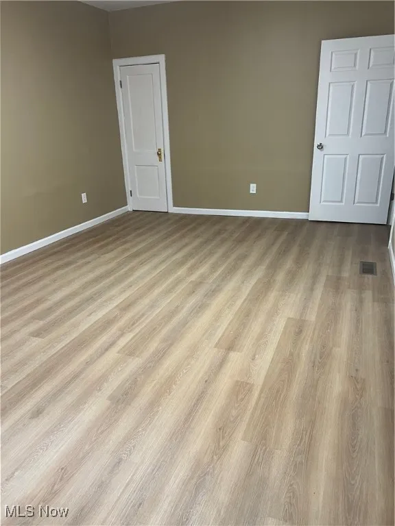 Empty room featuring baseboards and wood finished floors