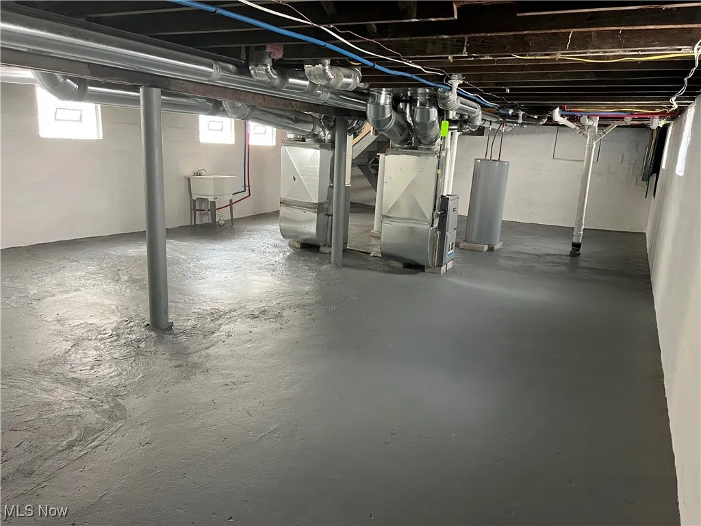 Below grade area featuring water heater and heating unit