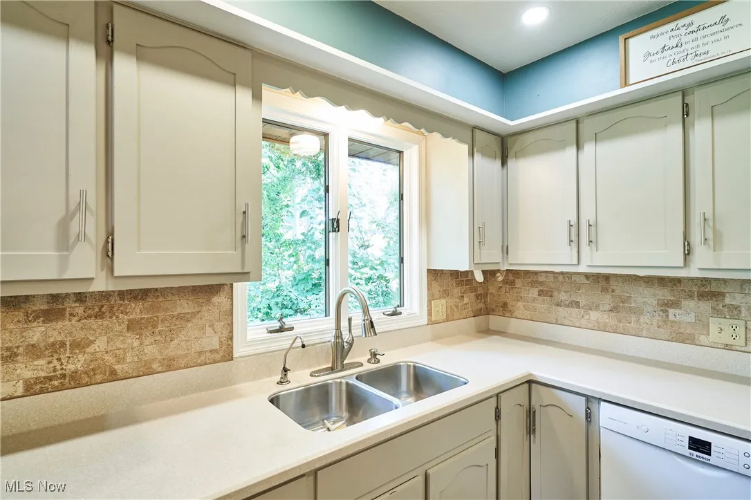 Corian counter tops, tile back splash, new dw and wonderful kitchen offers  window views