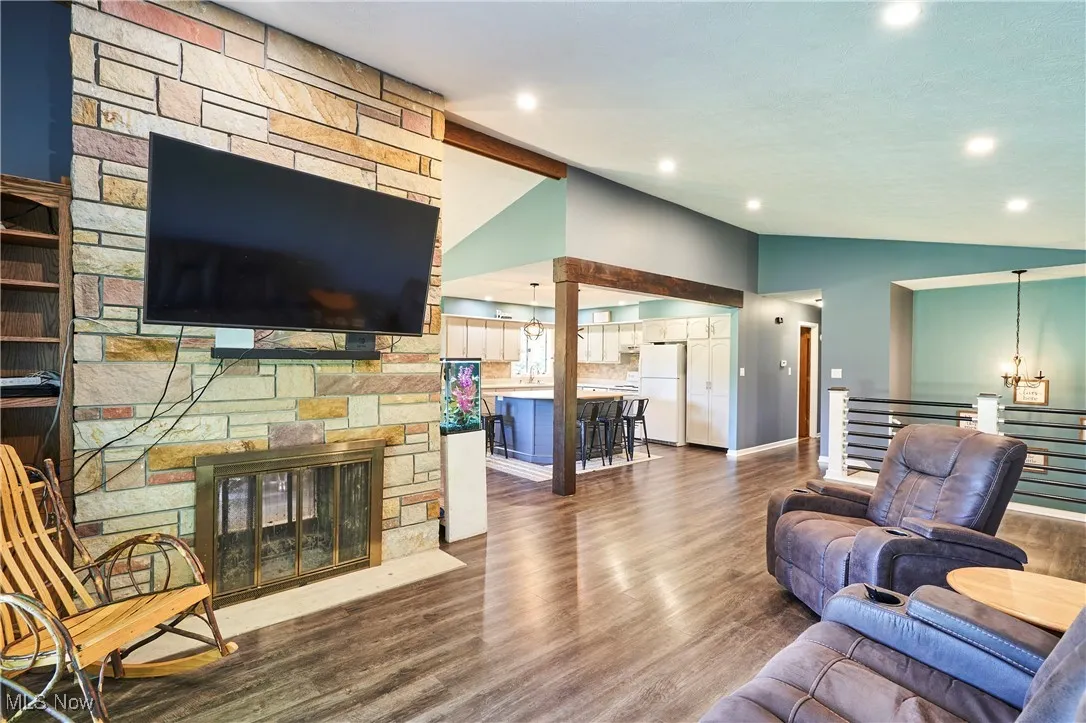 Living room featuring lofted ceiling, wood finished floors, and a fireplace