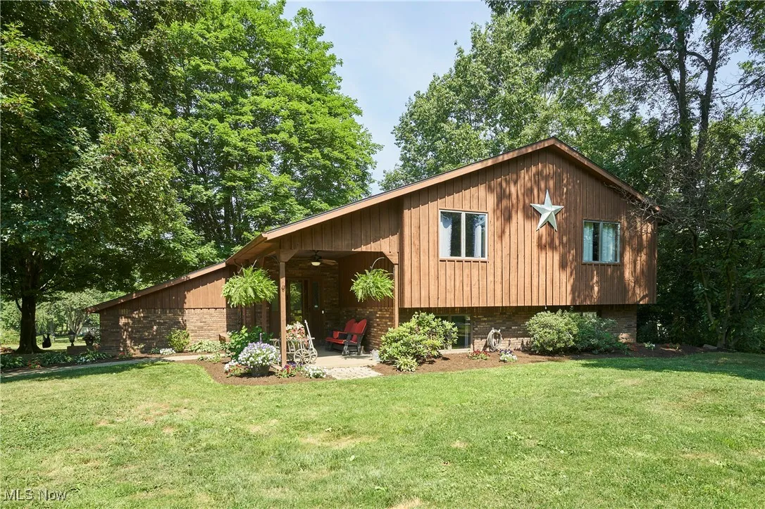 View of front of home featuring ceiling fan, a front yard, brick siding, and a patio
