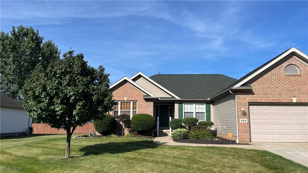 Single story home featuring an attached garage, concrete driveway, and roof with shingles