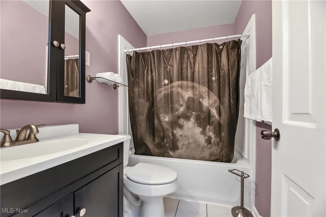 Full bathroom featuring vanity, shower / bath combo, and tile patterned floors