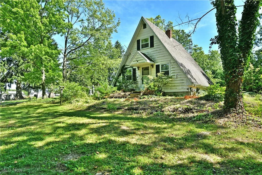 View of front of home with a chimney and a front yard