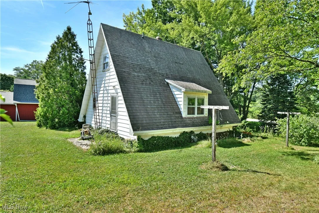 View of property exterior with roof with shingles and a yard
