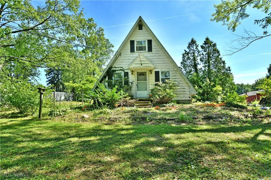 A-frame home featuring a front lawn and entry steps