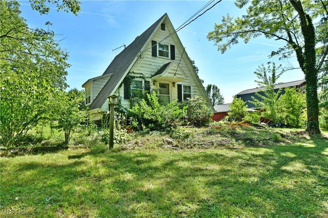 View of front of house with a front lawn and roof with shingles