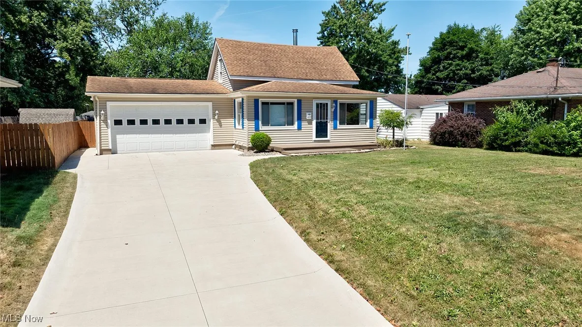 View of front facade featuring an attached garage, concrete driveway, and roof with shingles