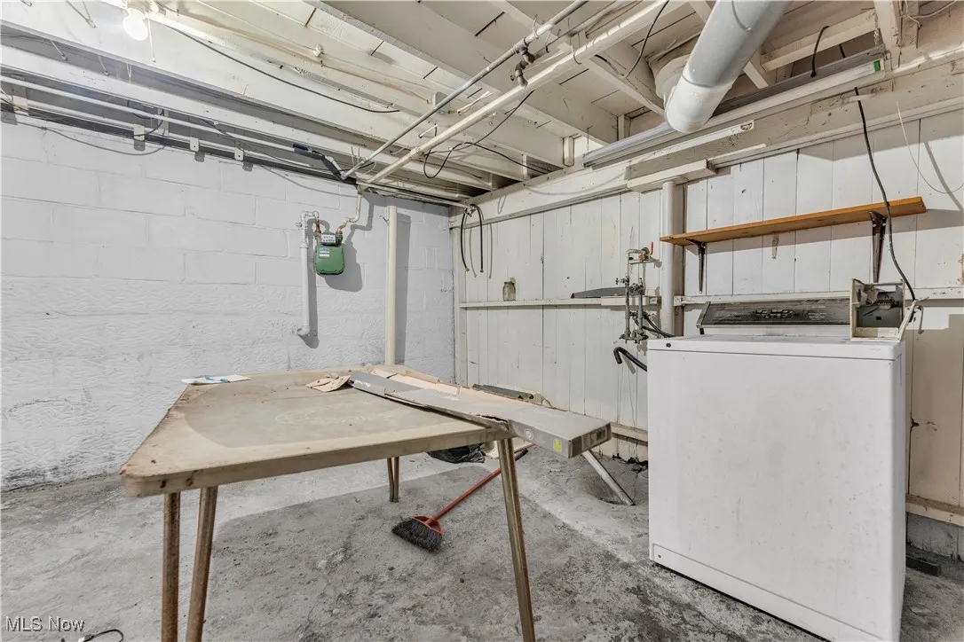 Unfinished basement featuring washer / dryer