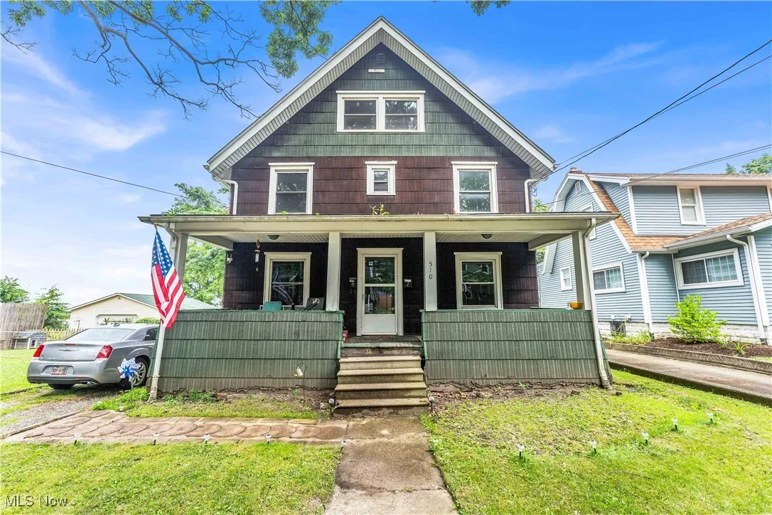 Traditional style home featuring a porch and a front yard