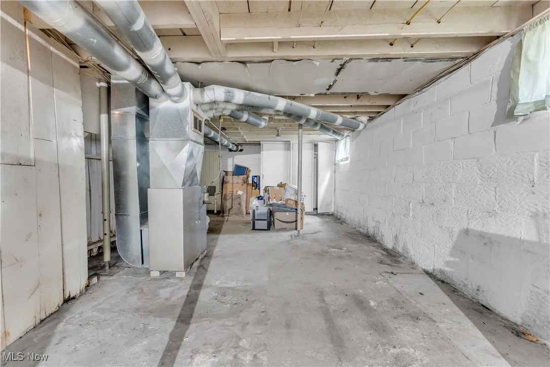 Below grade area featuring heating unit and healthy amount of natural light