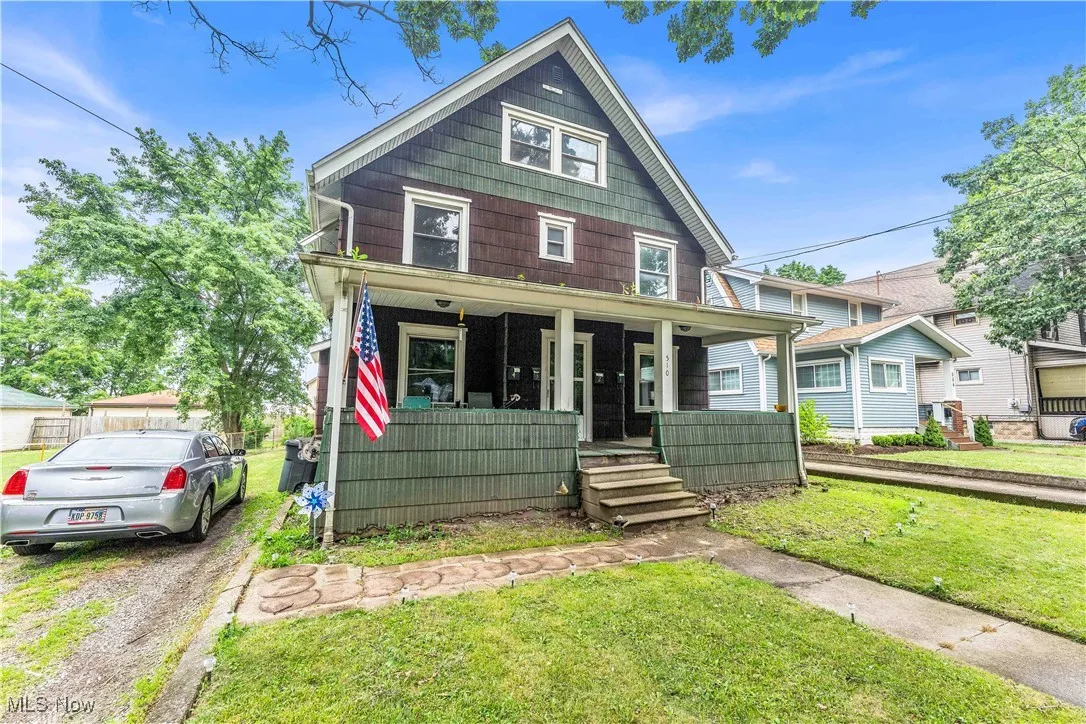 American foursquare style home featuring a porch and a front lawn