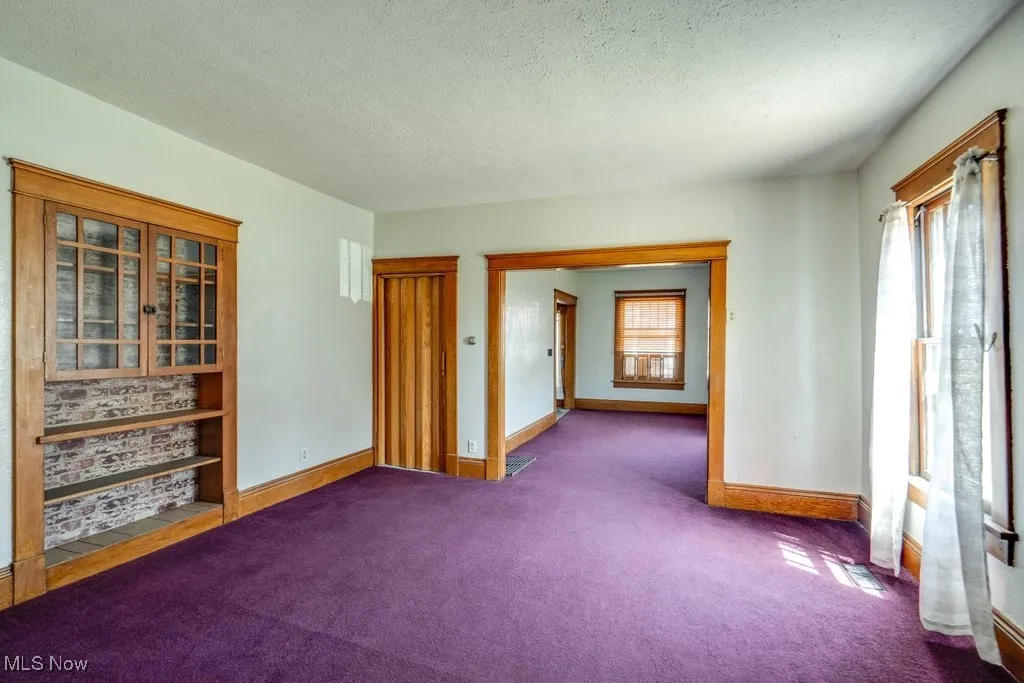 Spare room with a textured ceiling and carpet