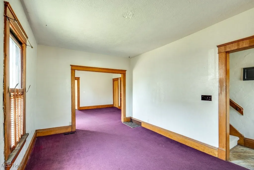 Carpeted empty room featuring baseboards and a textured ceiling