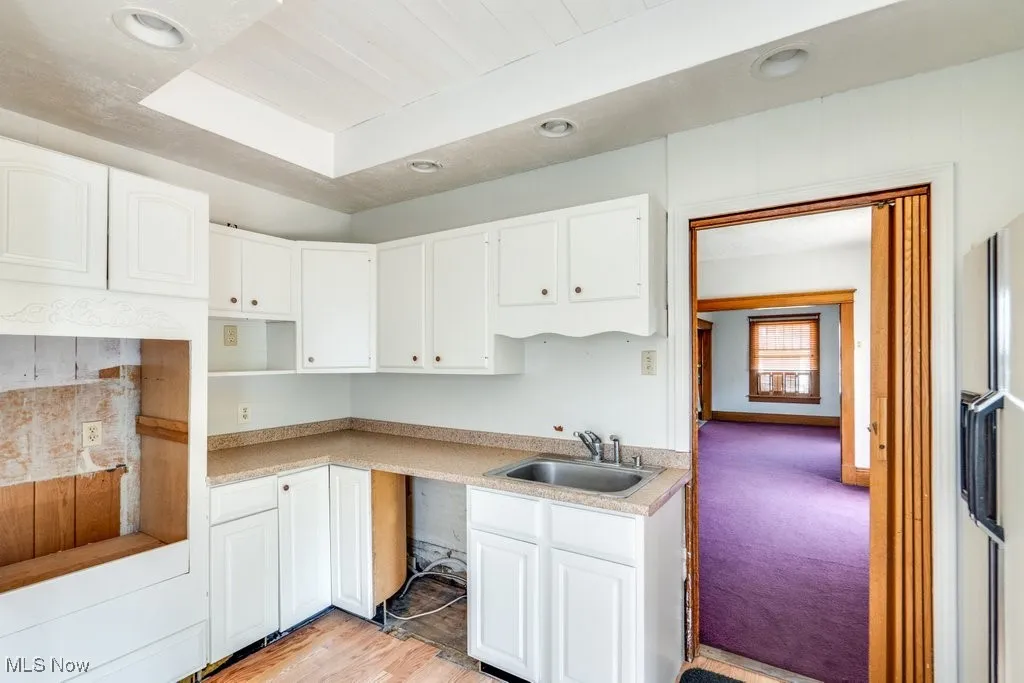 Kitchen with recessed lighting, white cabinetry, light wood finished floors, white fridge with ice dispenser, and light countertops