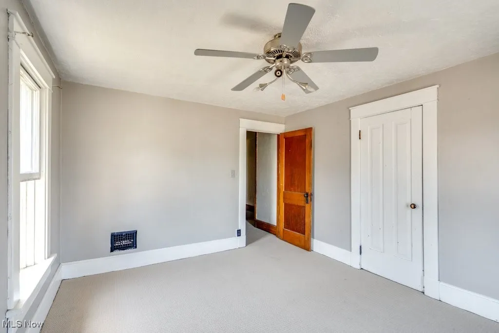 Unfurnished bedroom featuring carpet, a closet, and ceiling fan