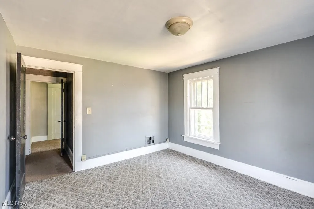 Spare room with carpet and baseboards