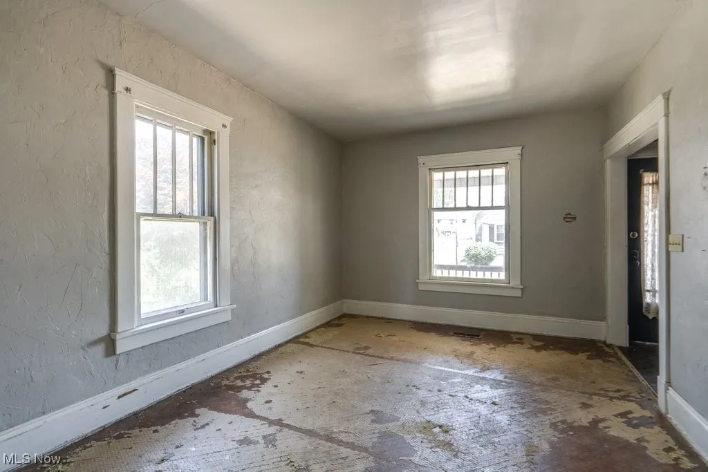 Spare room featuring healthy amount of natural light and a textured wall