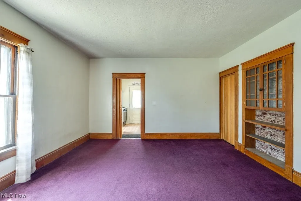 Spare room with dark colored carpet and a textured ceiling
