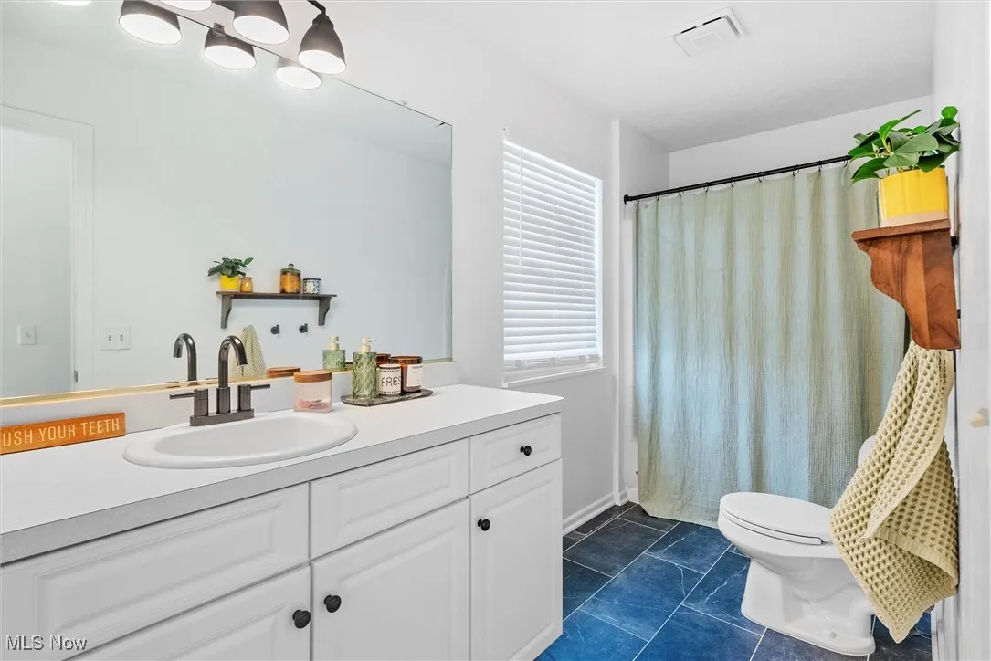 Bathroom featuring vanity, tile patterned flooring, and a shower with curtain