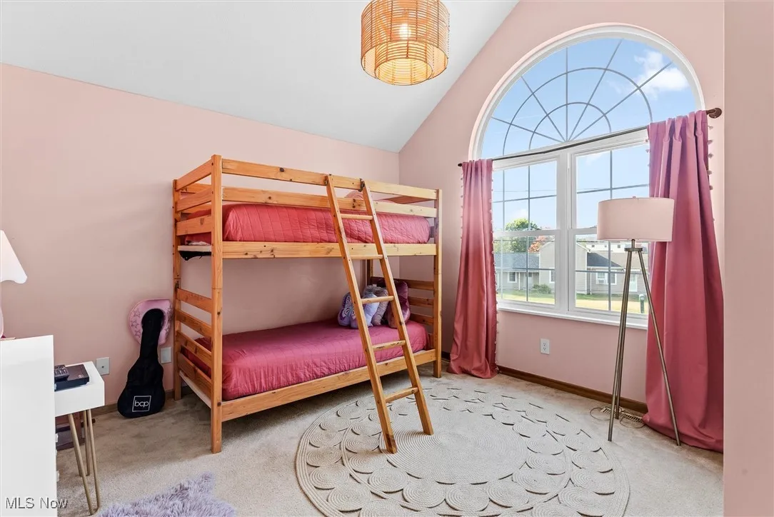 Bedroom with carpet floors and vaulted ceiling