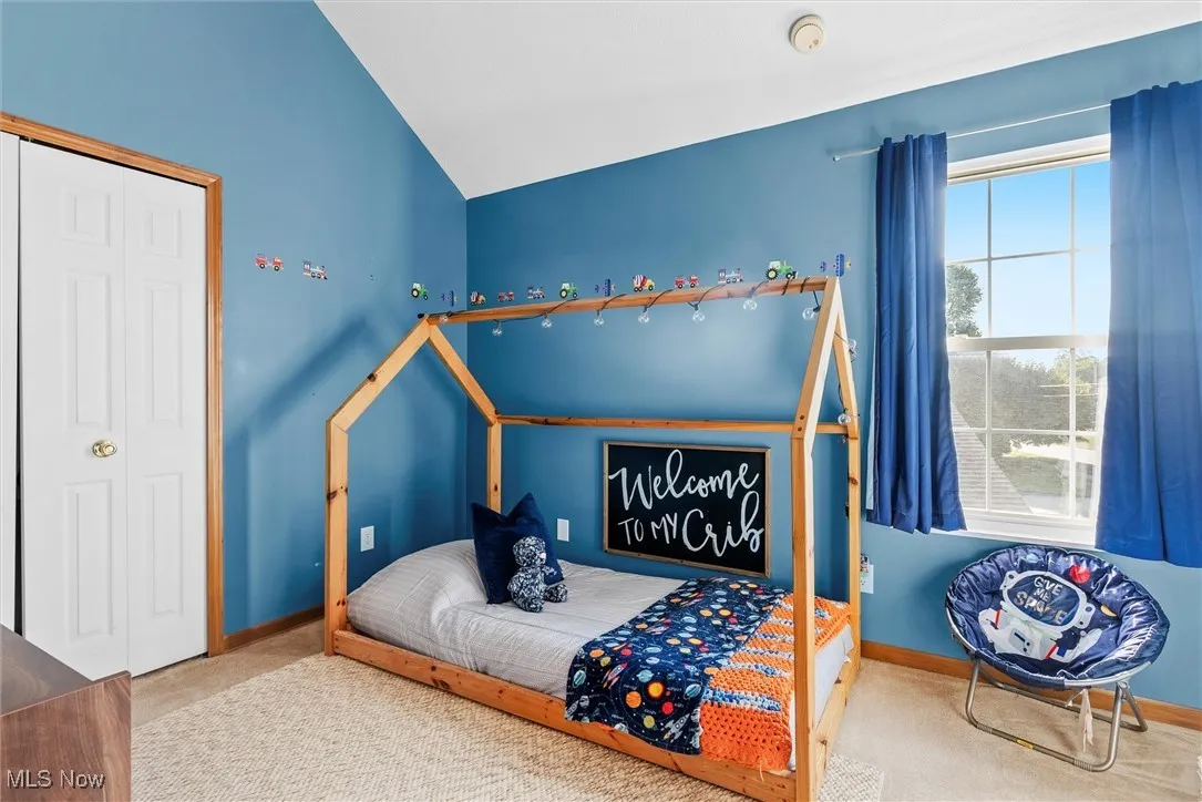Bedroom with carpet and vaulted ceiling