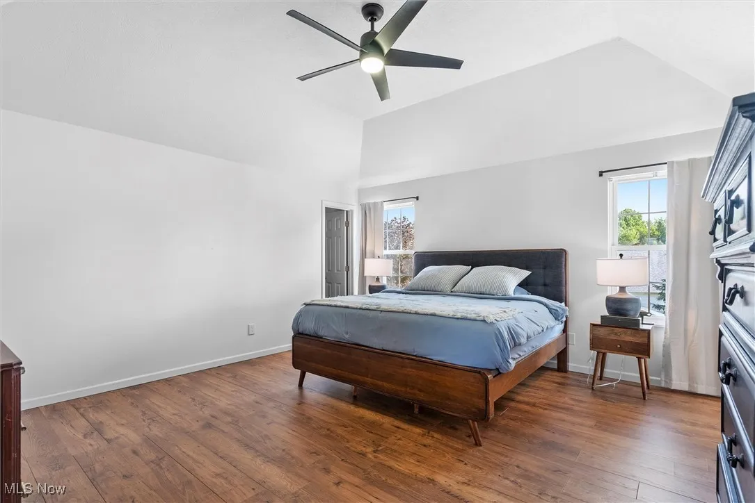 Bedroom with lofted ceiling, wood finished floors, and ceiling fan