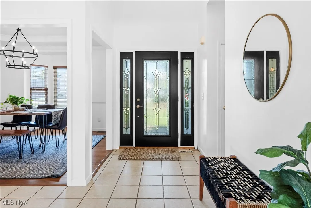 Entrance foyer featuring a chandelier and light tile patterned floors