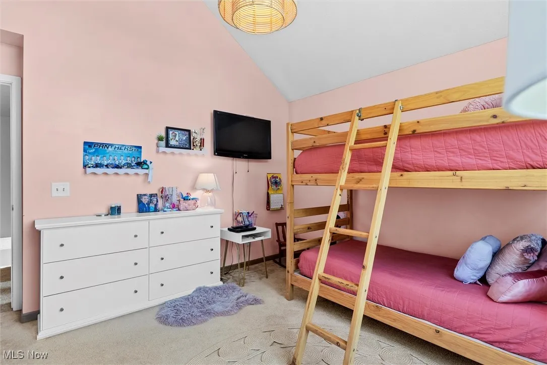 Bedroom with vaulted ceiling and carpet