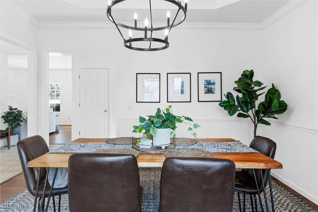 Dining space featuring ornamental molding, wood finished floors, and a chandelier