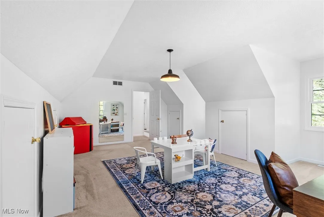 Office area featuring light colored carpet and lofted ceiling