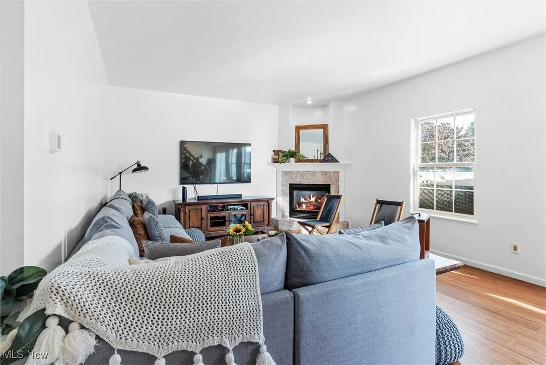 Living area featuring light wood finished floors and a high end fireplace