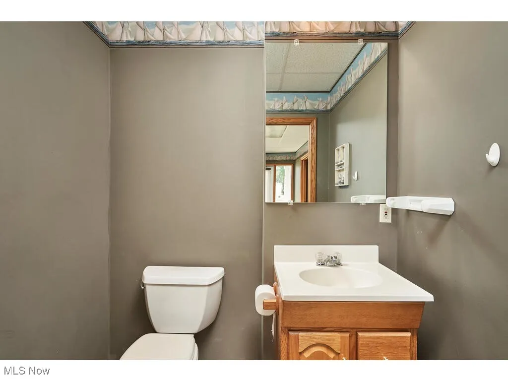 Bathroom featuring oversized vanity, a paneled ceiling, and toilet