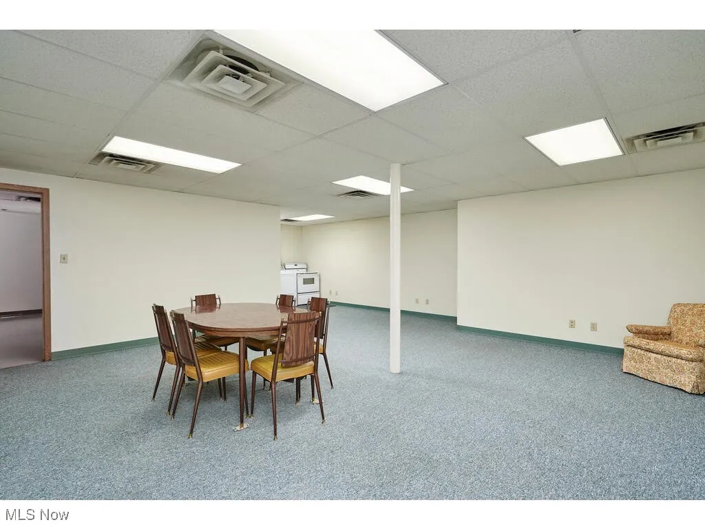 Dining area with a paneled ceiling and carpet floors