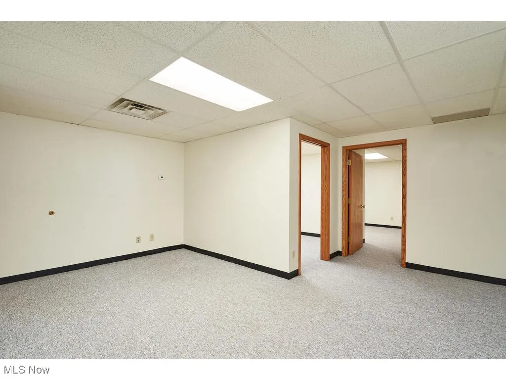 Carpeted spare room with a drop ceiling