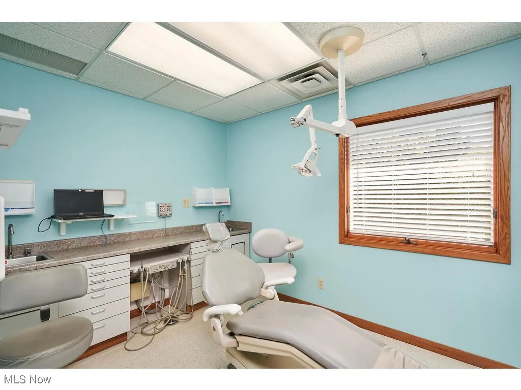 Office space with built in desk and a drop ceiling